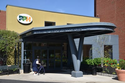 Building entrance with facility logo and welcoming sign