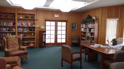 Interior of a facility library with a resident reading