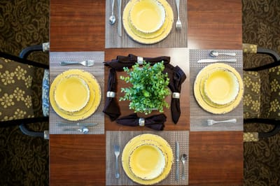 Dining table set with yellow plates and a centerpiece