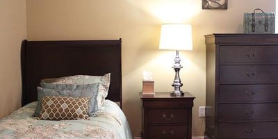Cozy private resident room with a bed and lamp