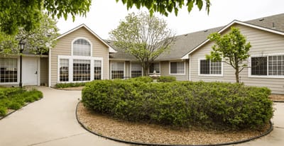 Exterior view of a senior living facility with gardens
