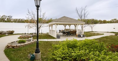 Outdoor gazebo with seating in a landscaped garden