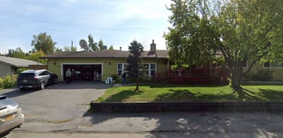 Exterior view of a senior living facility with a green lawn