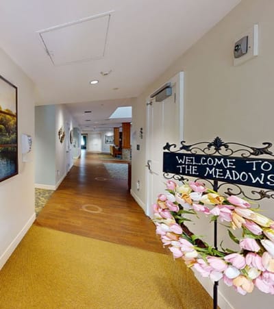 Hallway view with welcome sign and floral decor