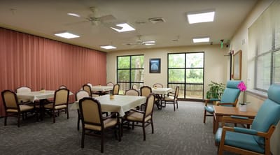 A common area with tables and chairs in a well-lit room