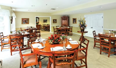 Dining area set for a meal with tables and chairs