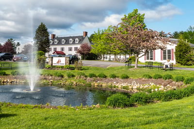 Exterior view of Schooner Estates with a fountain and garden