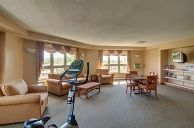 Bright common area with seating and exercise equipment