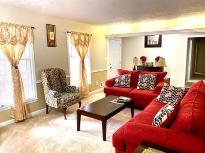 Cozy common area with red couches and floral curtains