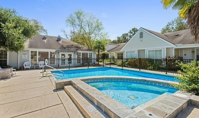 Outdoor pool area with surrounding gardens