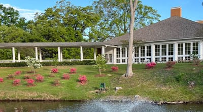 Exterior view of the facility with gardens and water feature