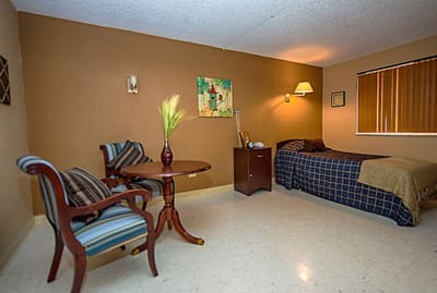 Cozy private resident room with bed and chairs