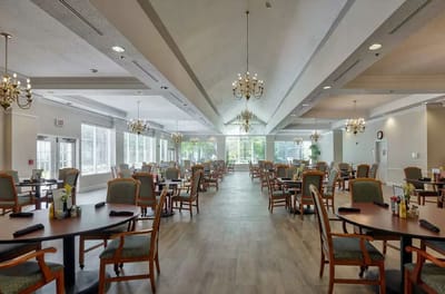 Brightly lit dining room with tables and chairs