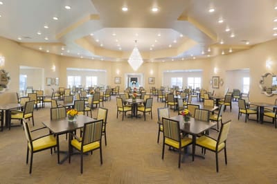 Bright dining room with tables and chairs set up