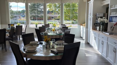 Bright dining room with large windows and flower centerpieces