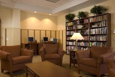 Interior view of a cozy common area with seating and bookshelves.