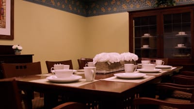 Dining area set with white dishware and flowers