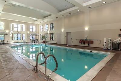 Indoor pool area with large windows and seating