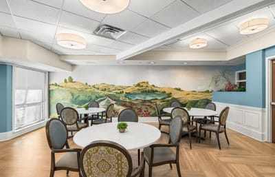 Bright dining area with a scenic mural and tables
