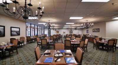 A dining room setup with tables and chandeliers