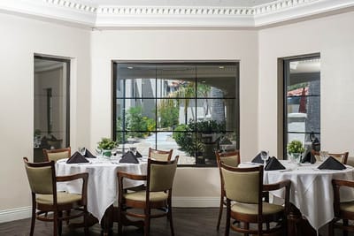 Dining area with tables overlooking an outdoor garden
