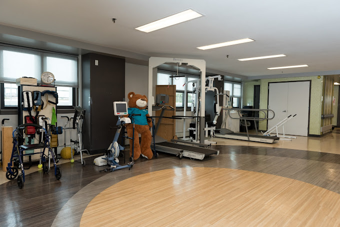 Rehabilitation gym with exercise equipment and a teddy bear