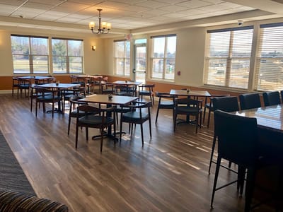 Dining room with tables and chairs arranged for residents