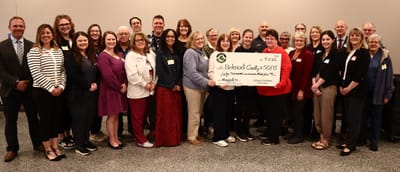 Group of people with a large check for a donation