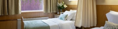 A well-furnished resident room with a bed and decor