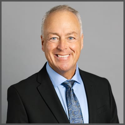 Smiling man in a business suit against a gray background
