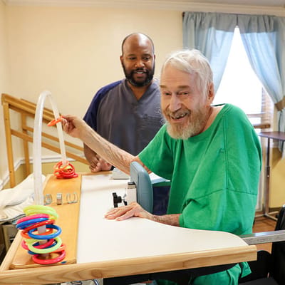 A resident engaging in therapy with staff support