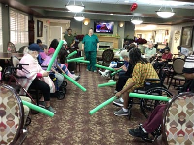 Residents participating in a group activity with foam noodles