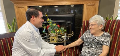A staff member and resident sharing a moment in a cozy lounge