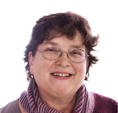 Smiling woman with glasses wearing a cozy scarf