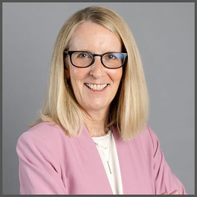 Professional portrait of a smiling woman in a blazer