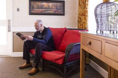 Resident reading a magazine in a cozy corner