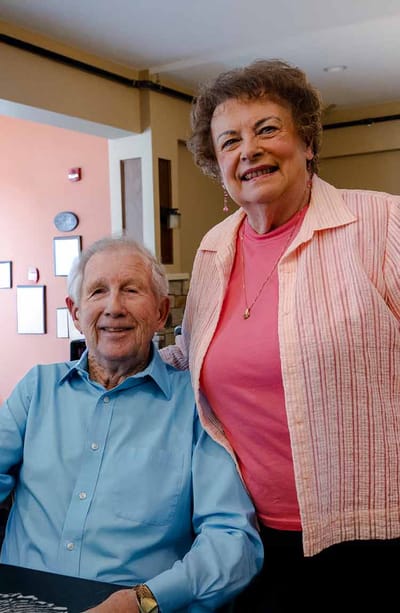 Two residents posing together in an interior space