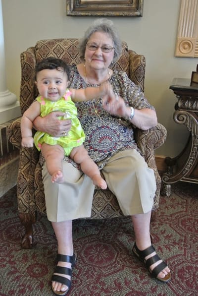 Elderly woman holding a baby in a cozy lounge