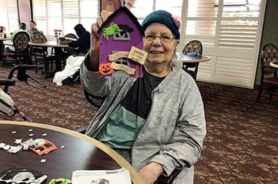 Senior resident crafting a decorative house