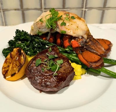 A gourmet plate featuring steak and lobster