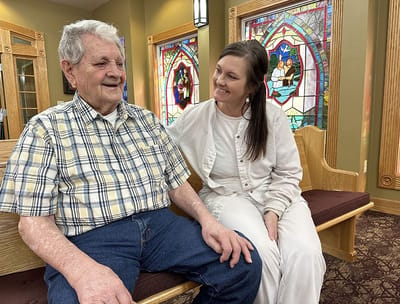 Senior resident conversing with a staff member in a cozy setting