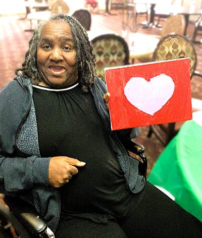 Resident proudly displaying their artwork in a common area