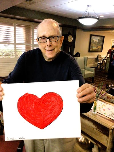 Resident holding a hand-drawn red heart