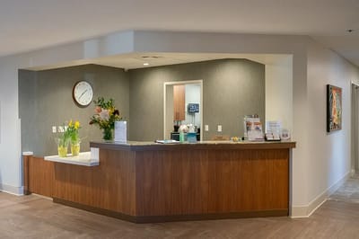Bright reception area with flowers and a clock