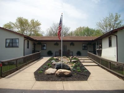 Main entrance of Hoover Haus with a flag and landscaped area