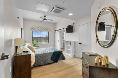 A well-decorated private resident room with a bed and furniture