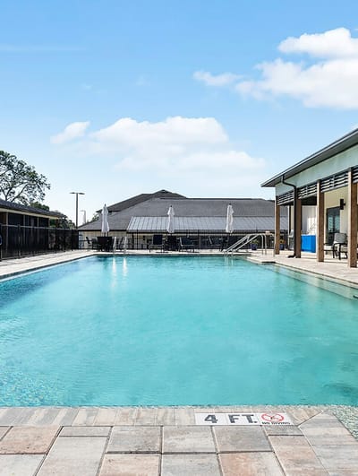 Outdoor pool area with lounge chairs and umbrellas