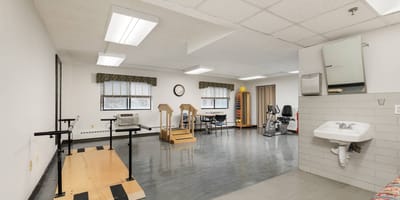 Interior activity room with exercise equipment and aids