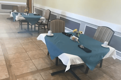 Dining room with neatly set tables and flowers