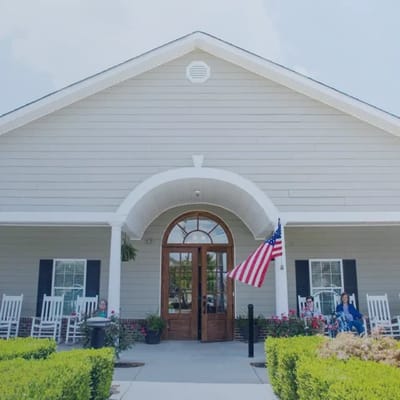 Exterior view of the facility entrance with rocking chairs